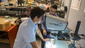 Electrical engineering junior Humberto Delgado (foreground) works with Mike Ranjram (background), an assistant professor of electrical engineering, on a FURI project to miniaturize power electronics to make data centers more energy-efficient.